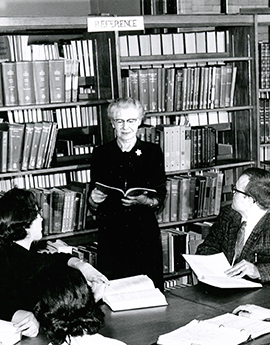 Florence Van Hoesen standing in a library